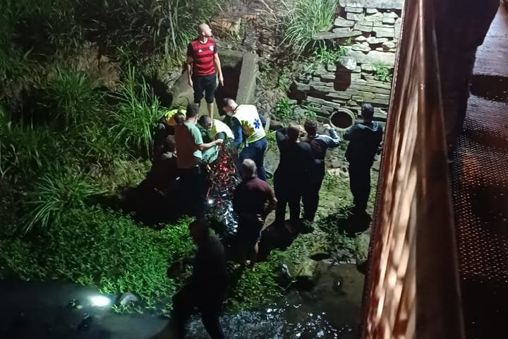 Três pessoas ficam feridas após veículo capotar em córrego